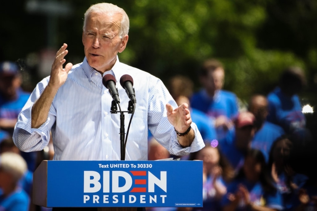 biden_1 | Imagely For these images, I found myself a spot a little further to the left of the stage, aiming to use the trees and the Biden supporters to create a more pleasing background, allowing the value of the highlights on Biden to draw the viewer into him. The division of the greens and blues of the background also creates a horizon-esque line, so it was important to keep it rather level and use it to draw towards my subject, rather than away from.