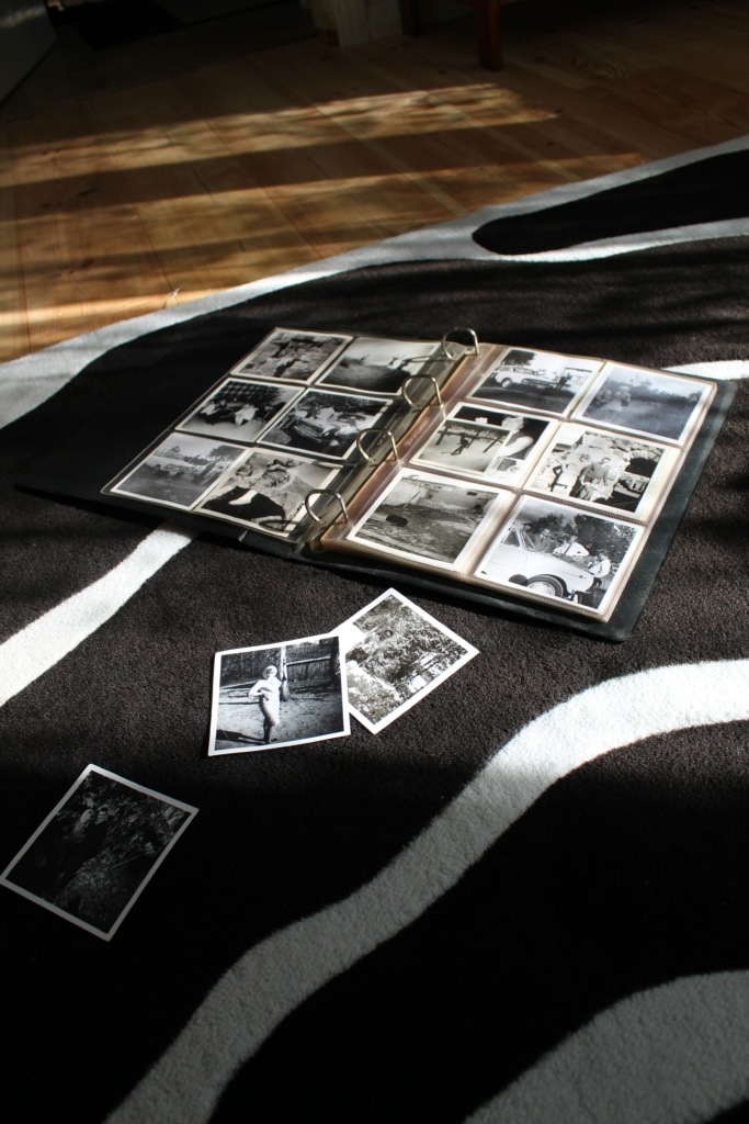 An album displaying black and white images lies on a black and white rug on the floor
