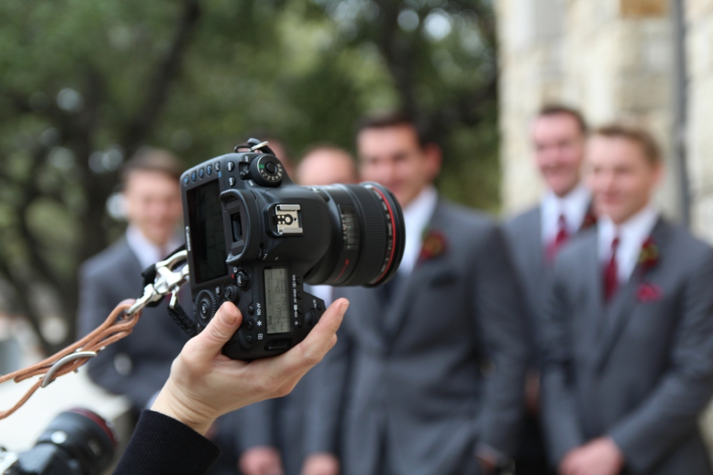 A person holding a DSLR through on one hand