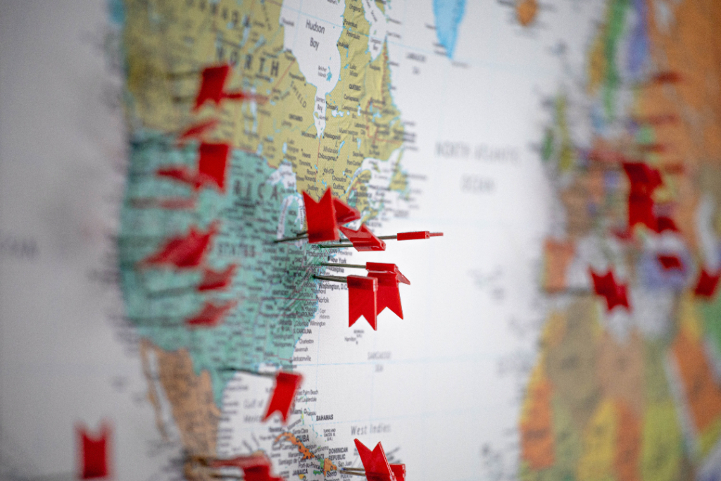 location tracking | Imagely Red flag-shaped thumb pins placed on a soft board map