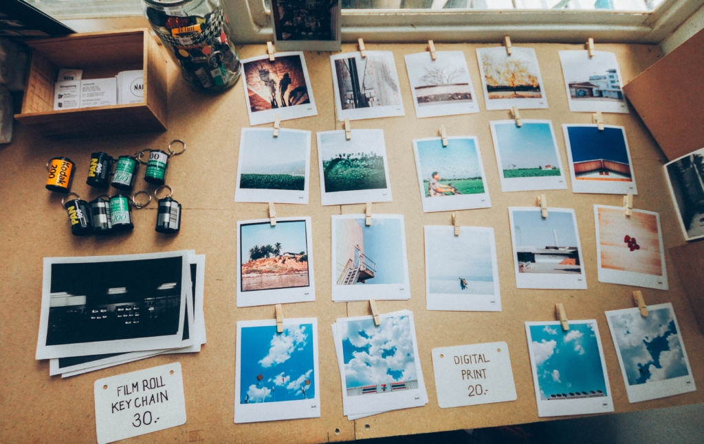 Multiple polaroid prints featuring landscape photography placed on top of a brown table