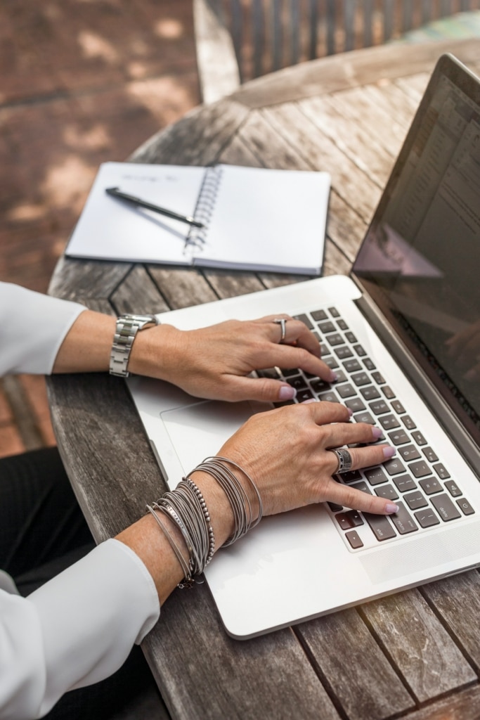 Close up shot of a woman's hands using a laptop’s keyboard