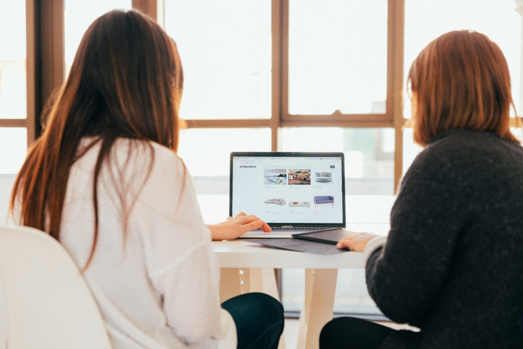 Over the shoulder shot of two women looking at the laptop screen